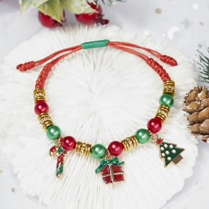 Christmas woven bracelet with Santa tree and candy cane charms on festive background