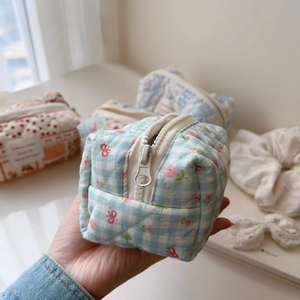 Macro detail of quilted cotton fabric texture on blue plaid floral makeup organizer bag