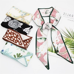 Dettaglio di vari foulard sottili in seta con stampe floreali e leopardate annodati a fiocco