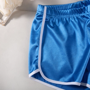 Detail of bright blue yoga shorts featuring white contrast binding and elastic waistband