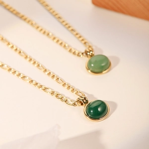 Detailed close-up of 18k gold plated necklaces with green zircon square pendants