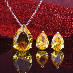 Detailed view of pear-cut yellow gemstones set in silver necklace and earrings