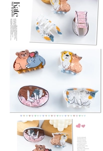 Detail of cute acetate hair claws with cartoon cat and dog patterns in pearlescent finish