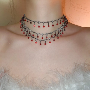 Close-up of layered black nickel choker with red crystals and rhinestones on model neck