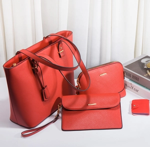 Detail view of a four-piece red Saffiano faux leather handbag set with tote and pouches