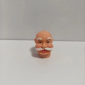 Macro detail of DIY 3D vinyl Santa Claus head with white beard and peach skin tone