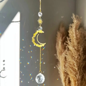 Detailed close-up of golden sun and moon suncatcher with yellow crystal accents