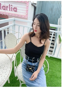 Outdoor model shot of a black quilted mini chain bag paired with a denim skirt outfit