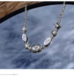 Detail of Y2K silver choker with butterfly pendant and square crystal in mirror reflection