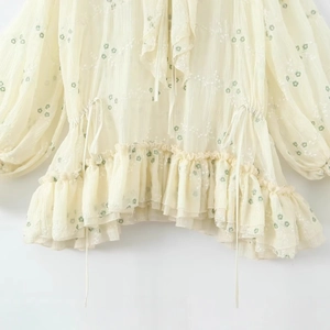 Elegante abito ricamato a fiori crema con vita a balze e dettagli dello scollo a V fine