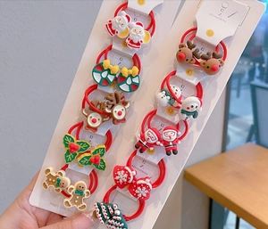 Détail d'élastiques à cheveux de Noël en résine avec Père Noël et renne sur carte de vente
