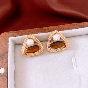 Detail of vintage gold triangle earrings featuring white pearl and brown tiger eye stone