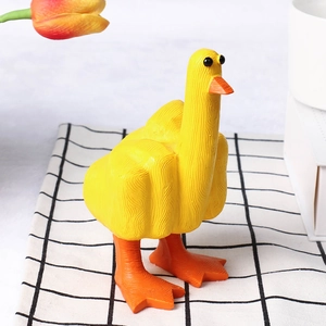 Detail view of the creative yellow resin duck figurine on a rustic plaid cloth background
