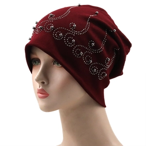 Detail of silver beads and rhinestone crown pattern on burgundy cotton slouchy beanie