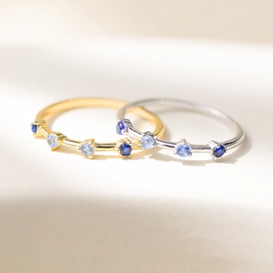 Delicate silver and gold rings with gradient blue zircon stones in a stackable design