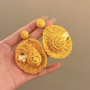 Fashionable yellow raffia straw hat earrings with white flower detail for summer beach vacations