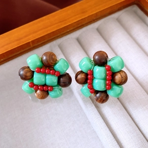 Detailed close-up of ethnic handmade resin and wood beaded earrings in a jewelry box