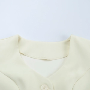 Detail shot of the round neckline and single button closure on this light yellow knit top