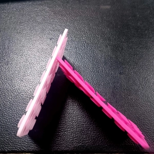 Detail view of pink silicone double-sided suction cups with serrated edges for phones
