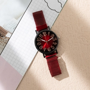 Détail du cadran rouge avec chiffres or rose et bracelet magnétique en maille