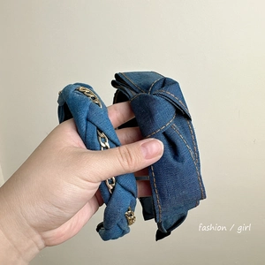 Detail of denim bow headband with chain weaving and classic contrast stitching