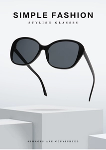 Close-up of black arc-shaped sunglasses with dark grey lenses on white display stand