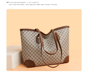 Detail of the brown leather trim and geometric monogram pattern on a large tote bag