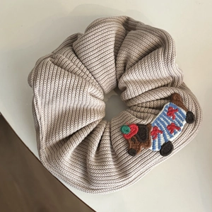 Cute beige knitted scrunchie with cartoon puppy embroidery and ribbed texture fabric