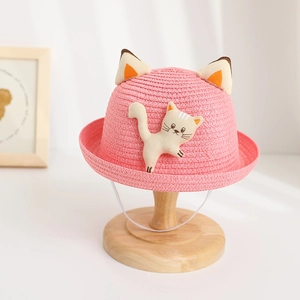 Détail d'un chapeau de paille rose pour filles avec oreilles de chat et tissage fin
