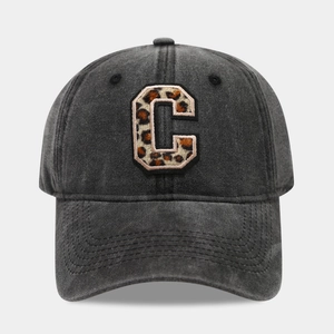 Detailed view of the leopard print letter C embroidery on a washed grey baseball cap