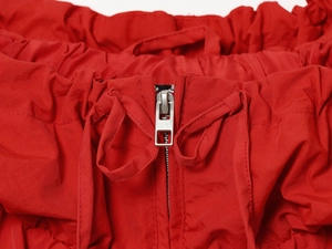Detail showing high-quality silver metal zipper and red nylon fabric with adjustable drawstrings