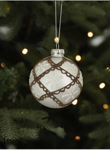 White matte Christmas glass ball with bronze glitter hanging on a festive tree branch