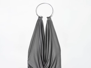 Detail of dark grey pleated maxi dress with silver metal ring neck decoration