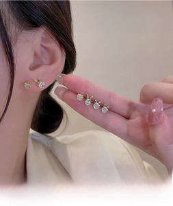 Close-up of golden animal-shaped stud earrings set with sparkling cubic zirconia stones