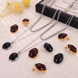 British vintage jewelry set with black pendants and mixed metal earrings on marble