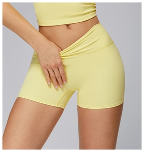 Dettaglio dei pantaloncini da yoga gialli a vita alta che mostrano il tessuto spazzolato