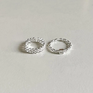 Detail of 925 sterling silver ring set featuring hollow hearts and chain link zircon design