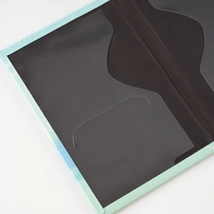 Detail of mint green PU leather passport holder with black interior and clear card slots