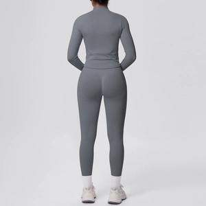 Dettaglio dei leggings yoga grigi a vita alta e del top a compressione a maniche lunghe da dietro