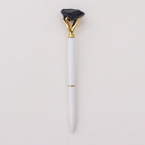 Detail van witte balpen met gouden clip en zwarte ruwe kristalsteen op de bovenkant