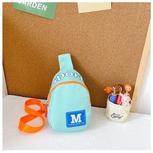 Détail du sac de poitrine en nylon vert menthe pour enfants avec sangle orange contrastée