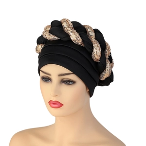 Close-up of black turban with gold sequined braided trim on a mannequin head