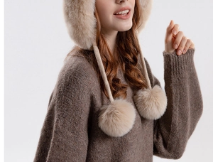 Close-up of soft khaki plush winter hat with fluffy pom-poms and warm ear protection