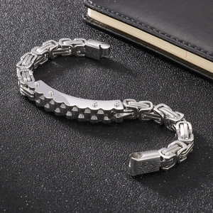 Men's silver Byzantine chain bracelet with rivet-embellished metal plate on dark surface