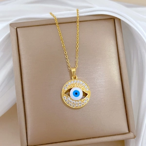 Evil eye necklace with blue center and crystal halo on golden jewelry box stand