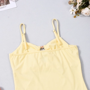 Detail of light yellow cutout strap top with elegant resin ring hardware connectors