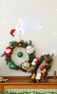 Detail of plush Christmas Santa, reindeer, and bear ornaments on a festive pine wreath