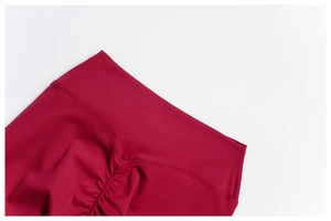Detail of high waist seamless waistband and scrunch butt stitching on red yoga pants