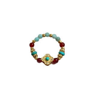 Ethnic style stretch ring with gold plating, tiger eye stone beads and floral charm
