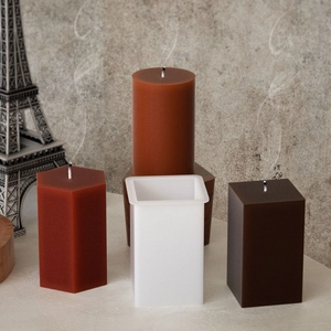 Detail showing white silicone candle molds and textured pillar candles in various shapes